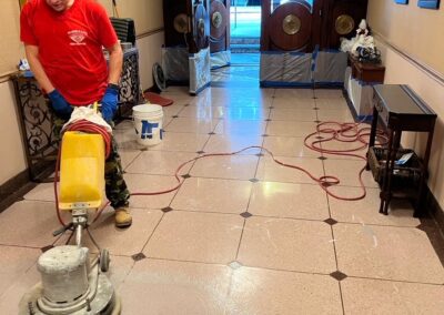 A man in a red shirt is using a floor scrubber