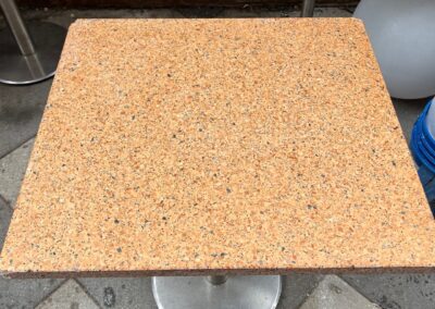 A table with a square top on a tiled floor