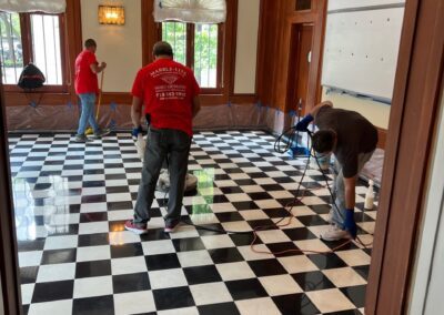 A couple of men standing and working on top of a black and white checkered floor